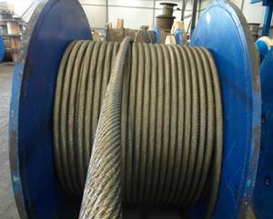 A large metal cable spool with a wire on it.